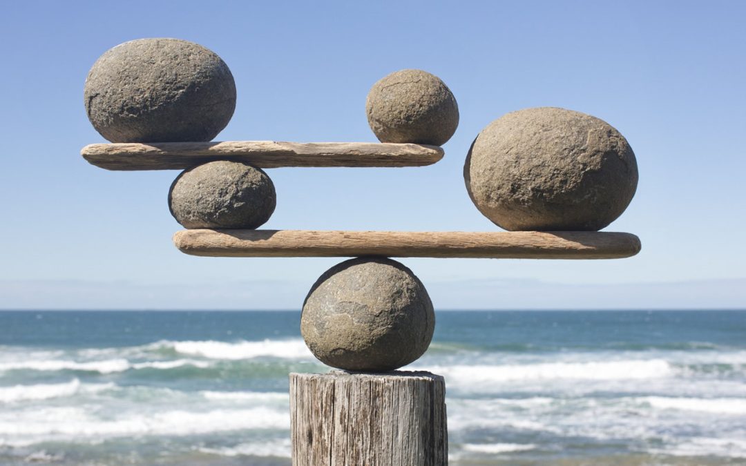 Rocks carefully stacked on a post near the ocean